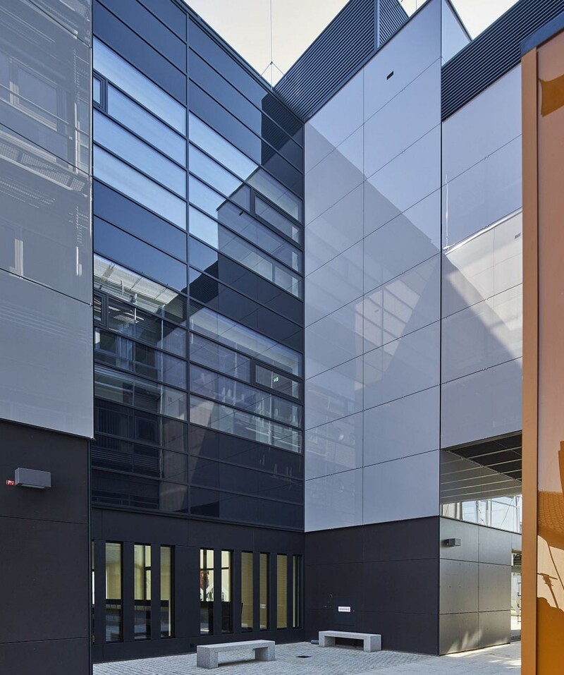 Spiegelnde Glasflächen umspielen das Gebäude, weiten die Zwischenräume und vermitteln Großstadtflair