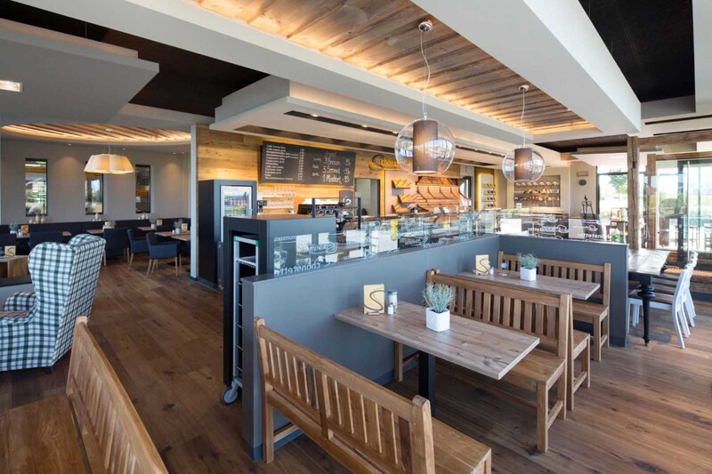 Holz und Naturstein im Verkaufsraum und im Restaurant stehen für Bodenständigkeit und gewachsene Werte