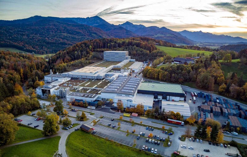 In einem Tunnel über den Dächern des Werks befördert eine freitragende Elektrohängebahn Paletten